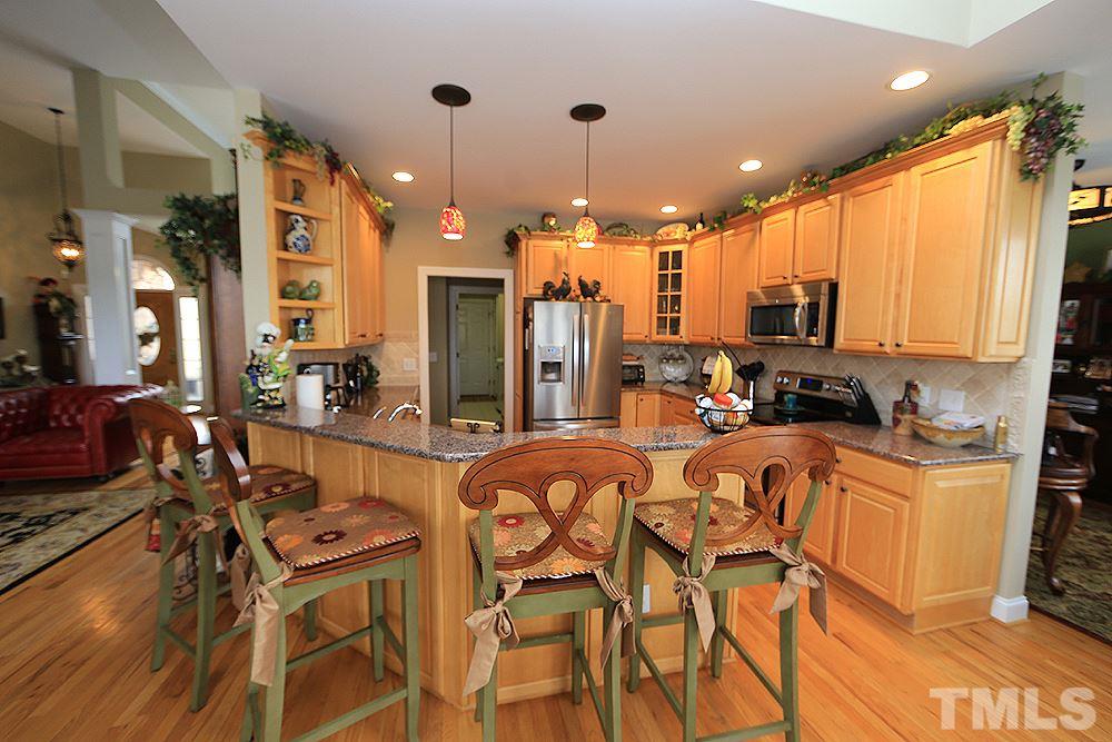 521 Competition Road Raleigh, NC 27603 - Photo 7 of 25 Gracious kitchen with custom 42" cabinetry and rope trim. Solid surface countertops with ceramic backsplash. Maytag SS appliances, roll out cabinetry.