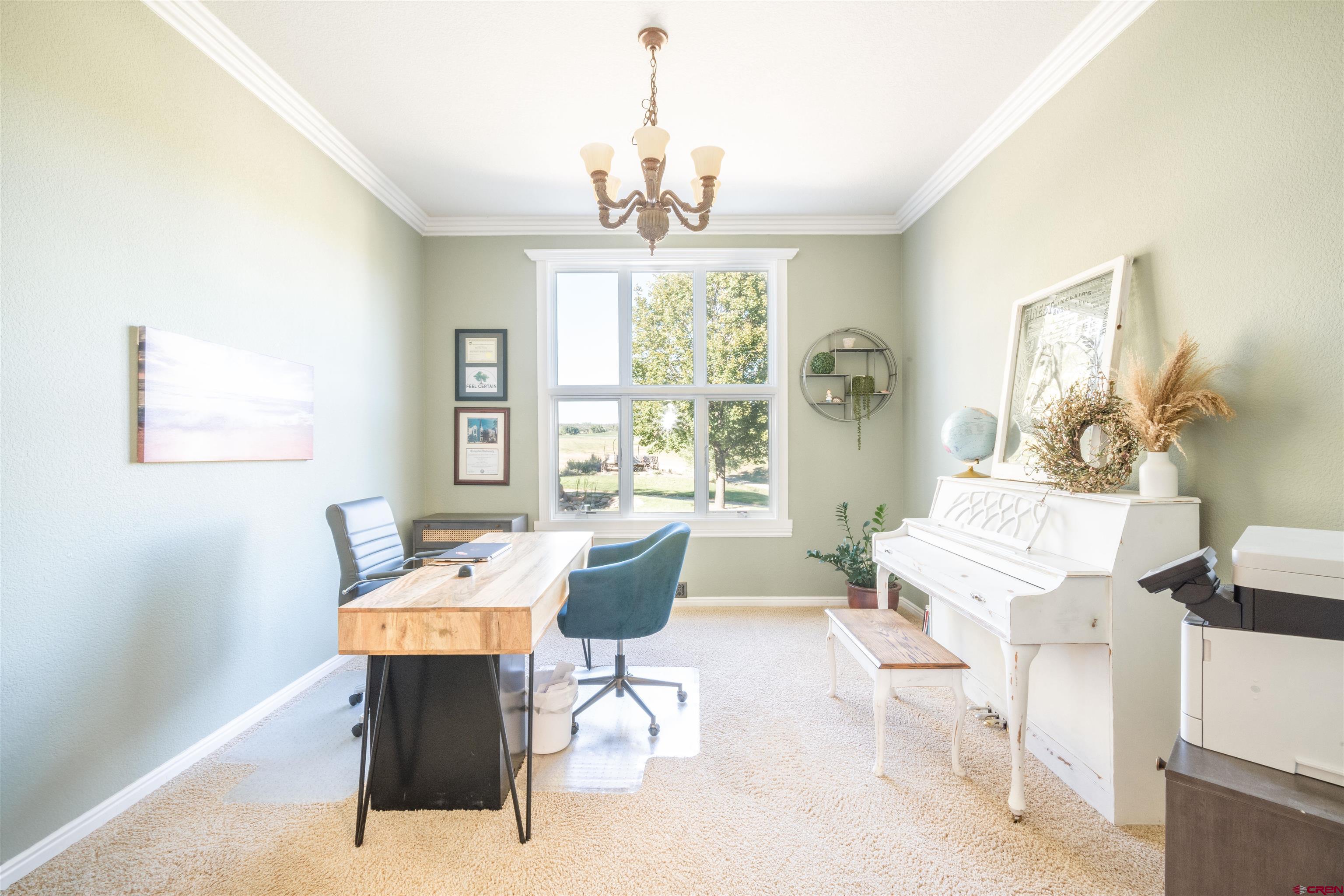 25266 Rd P Cortez, CO 81321 - Photo 14 of 41 a dining room with wooden floor a chandelier a wooden table and chairs
