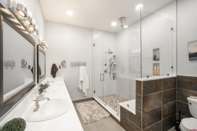 a bathroom with a sink a toilet and shower