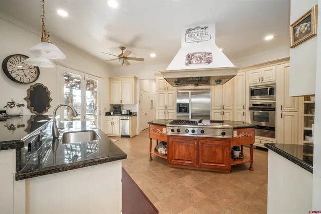 a large kitchen with stainless steel appliances granite countertop a stove oven and a sink with cabinets