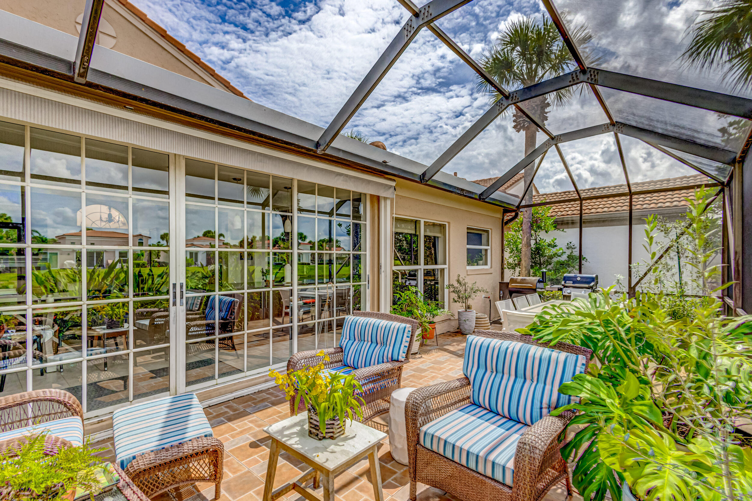 3546 Lantern Bay Drive Jupiter, FL 33477 - Photo 21 of 25 a view of a patio with couches table and chairs and potted plants