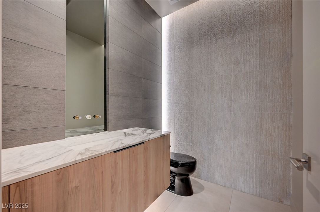 607 Grand Rim Drive Henderson, NV 89012 - Photo 16 of 30 Half bathroom with tile walls and vanity