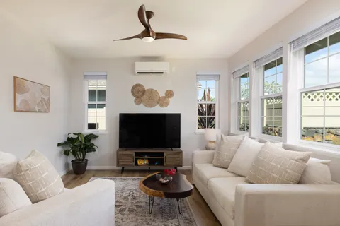 a living room with furniture a flat screen tv and a large window