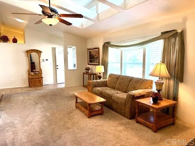 a living room with furniture a flat screen tv and a large window