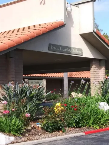 a view of a house with a garden and a car park in front of it