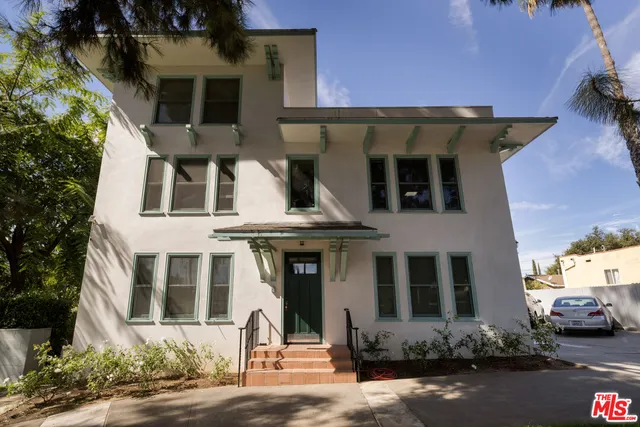 a view of a patio with table and chairs and a large tree