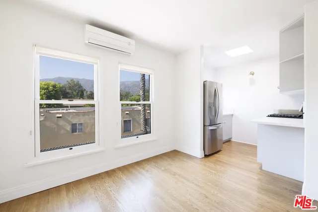 a view of kitchen with refrigerator and wooden floor