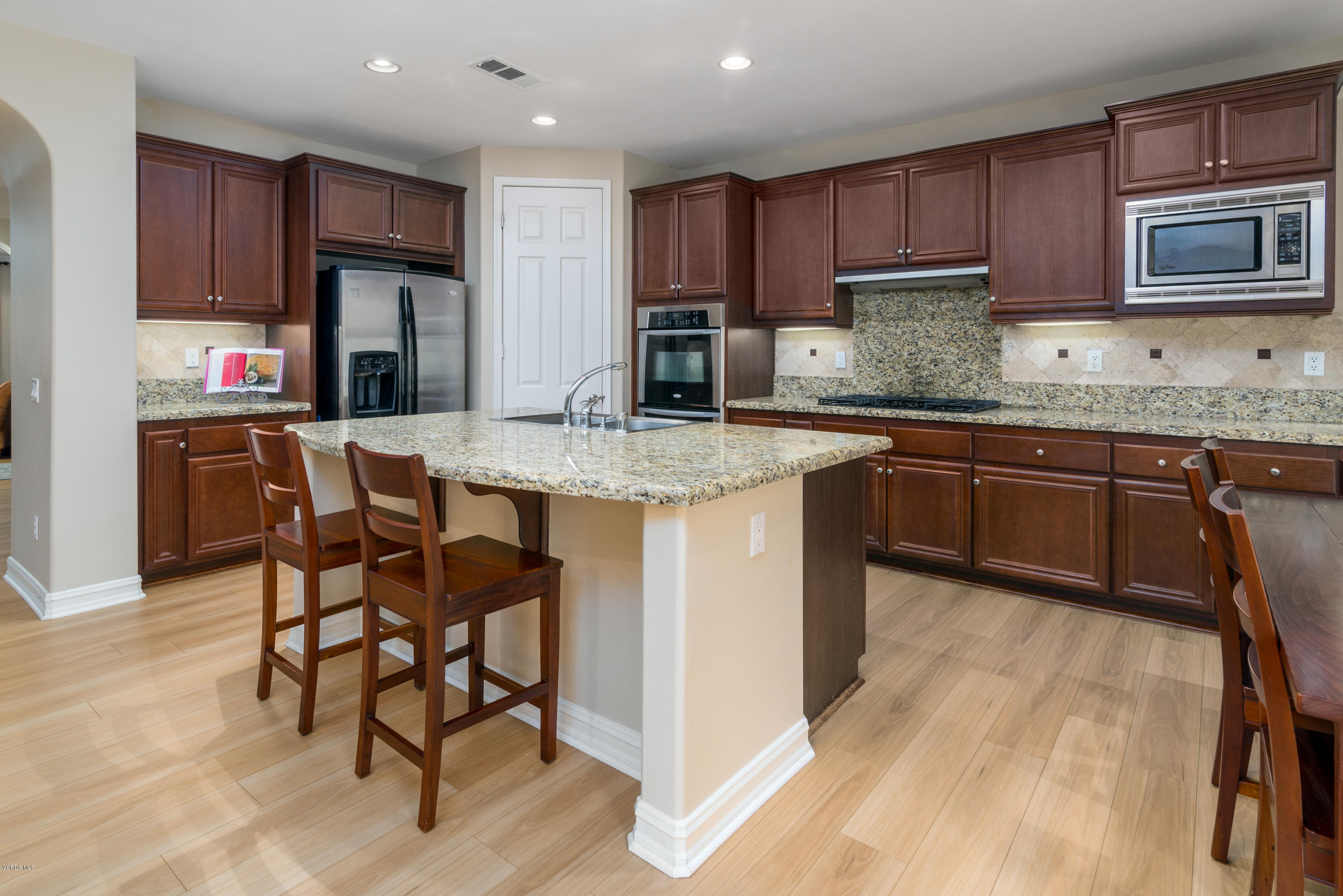 310 Spring Park Road Camarillo, CA 93012 - Photo 20 of 48 a kitchen with kitchen island granite countertop wooden cabinets a stove a microwave a island with stainless steel appliances