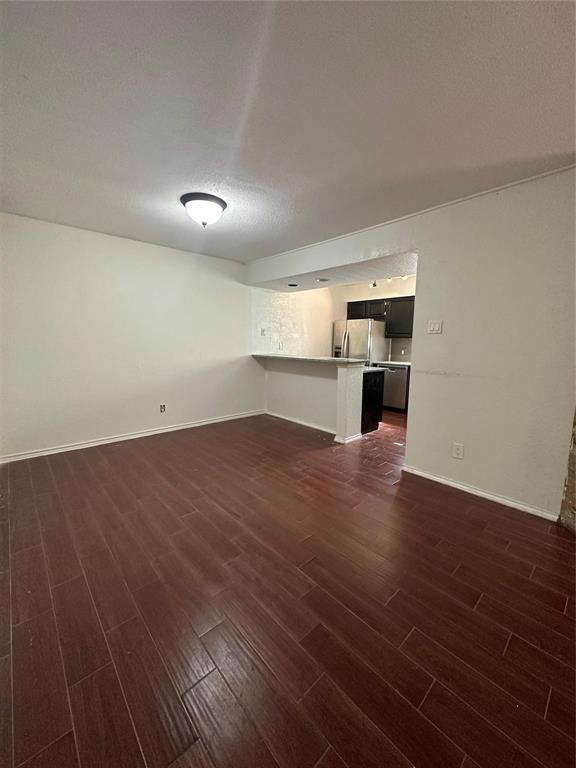 15221 Berry Trail, Unit 1003 Dallas, TX 75248 - Photo 2 of 17 an empty room with wooden floor cabinet and windows