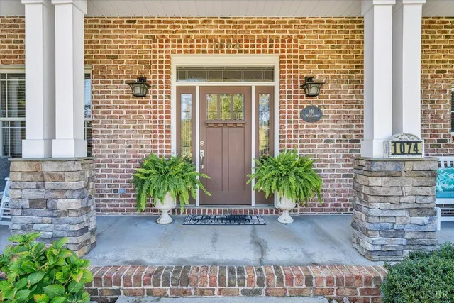 a living room with fireplace furniture and a potted plant