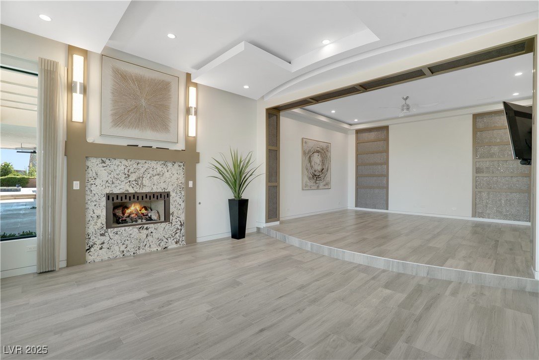10 Ridge Blossom Road Las Vegas, NV 89135 - Photo 20 of 69 Primary bedroom and sitting room with ceiling fan, light wood-style floors, a tile fireplace, and recessed lighting