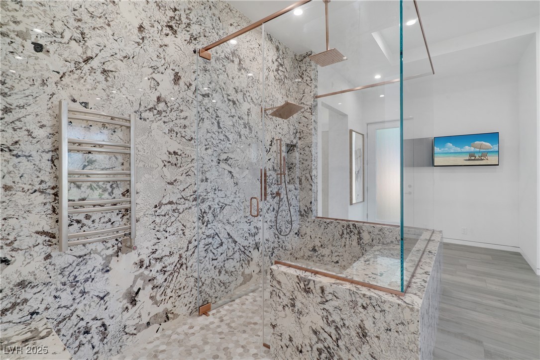 10 Ridge Blossom Road Las Vegas, NV 89135 - Photo 26 of 69 Bathroom featuring a towel warmer, a marble finish shower, recessed lighting, and wood finished floors