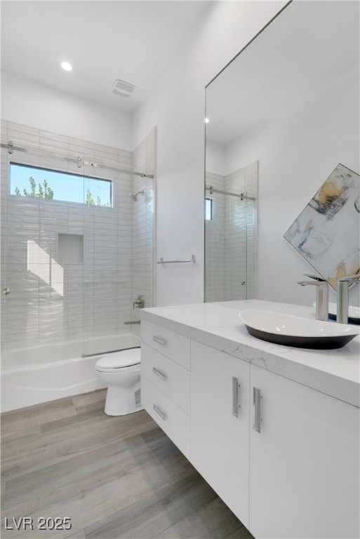 10 Ridge Blossom Road Las Vegas, NV 89135 - Photo 37 of 69 Bathroom featuring bath / shower combo with glass door, vanity, light wood-style floors, and recessed lighting