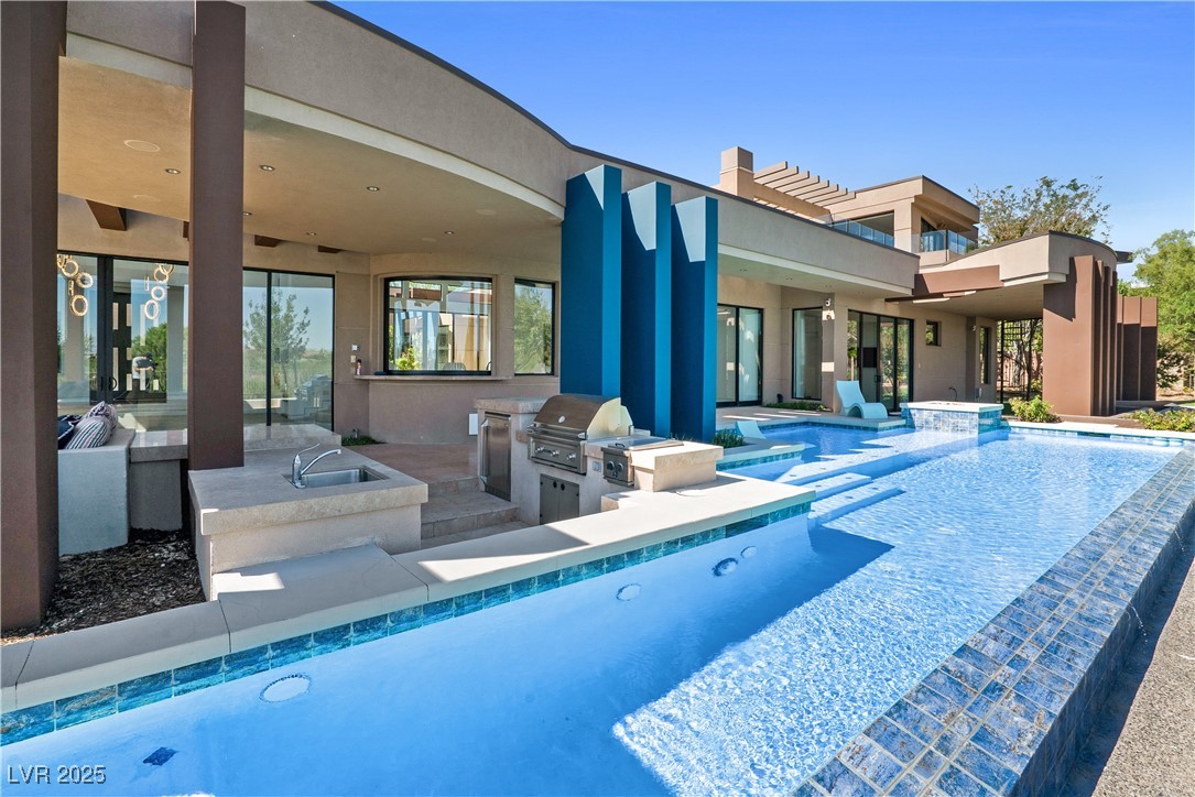 10 Ridge Blossom Road Las Vegas, NV 89135 - Photo 59 of 69 View of swimming pool with exterior kitchen, an infinity pool, a patio area, and a jacuzzi