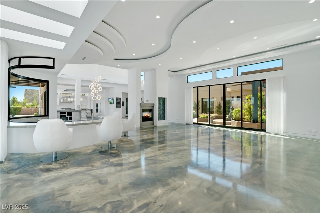 10 Ridge Blossom Road Las Vegas, NV 89135 - Photo 6 of 69 Living area featuring a chandelier, a glass covered fireplace, recessed lighting, and a high ceiling