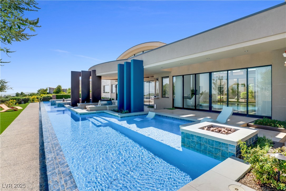 10 Ridge Blossom Road Las Vegas, NV 89135 - Photo 62 of 69 Outdoor pool with an outdoor fire pit, exterior kitchen, and a patio area