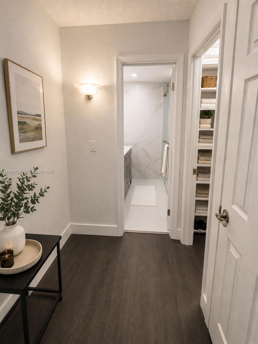 299 Northwest 52nd Terrace, Unit PHX Boca Raton, FL 33487 - Photo 2 of 16 a view of a hallway with wooden floor and a bathroom