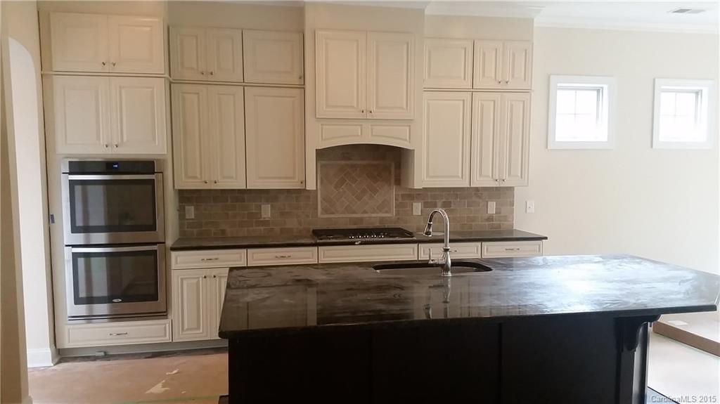 720 Chase Court, Unit 123 Fort Mill, SC 29708 - Photo 7 of 19 a kitchen with kitchen island granite countertop a stove a sink and a refrigerator