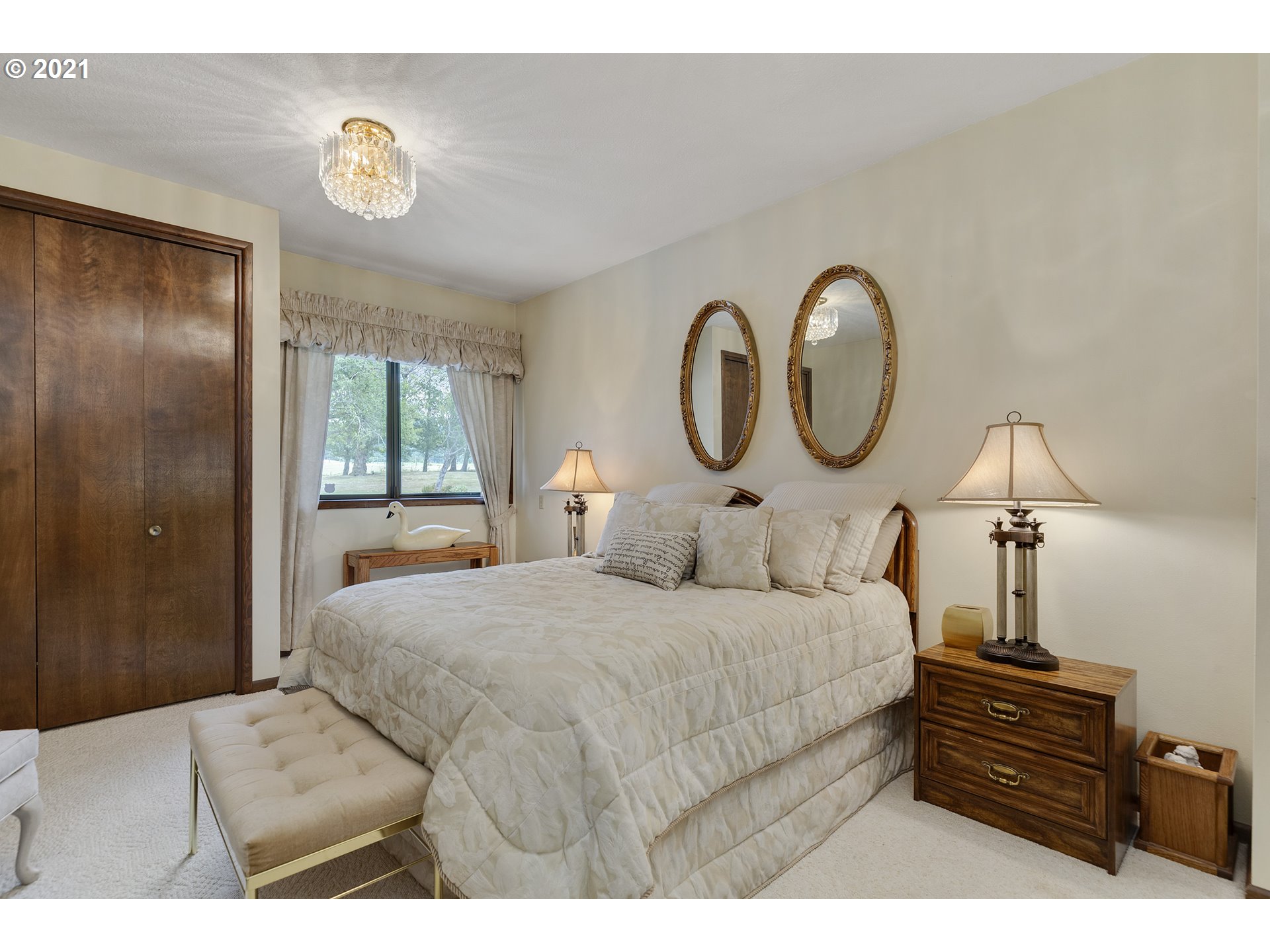 201 Northeast Salzman Road Corbett, OR 97019 - Photo 14 of 32 a bedroom with a bed and a chandelier