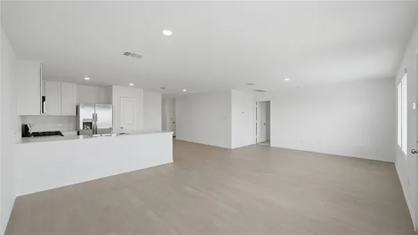 a view of a kitchen with refrigerator and white cabinets