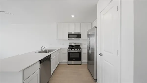 a kitchen with stainless steel appliances granite countertop a refrigerator and a sink
