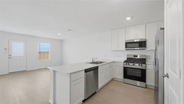 a kitchen with granite countertop stainless steel appliances and white cabinets