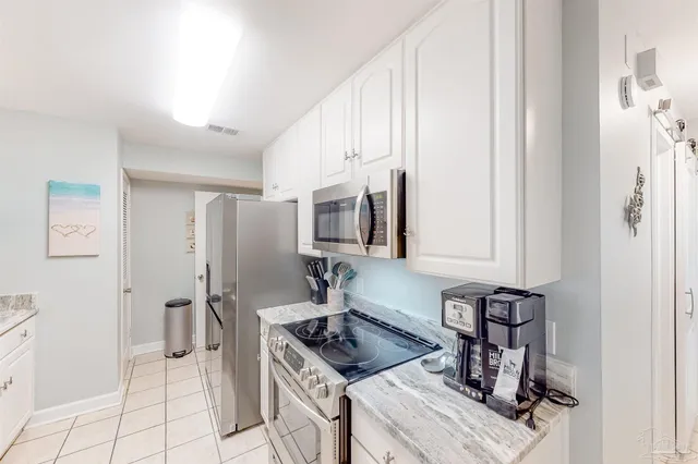 a kitchen with stainless steel appliances granite countertop a sink and a refrigerator