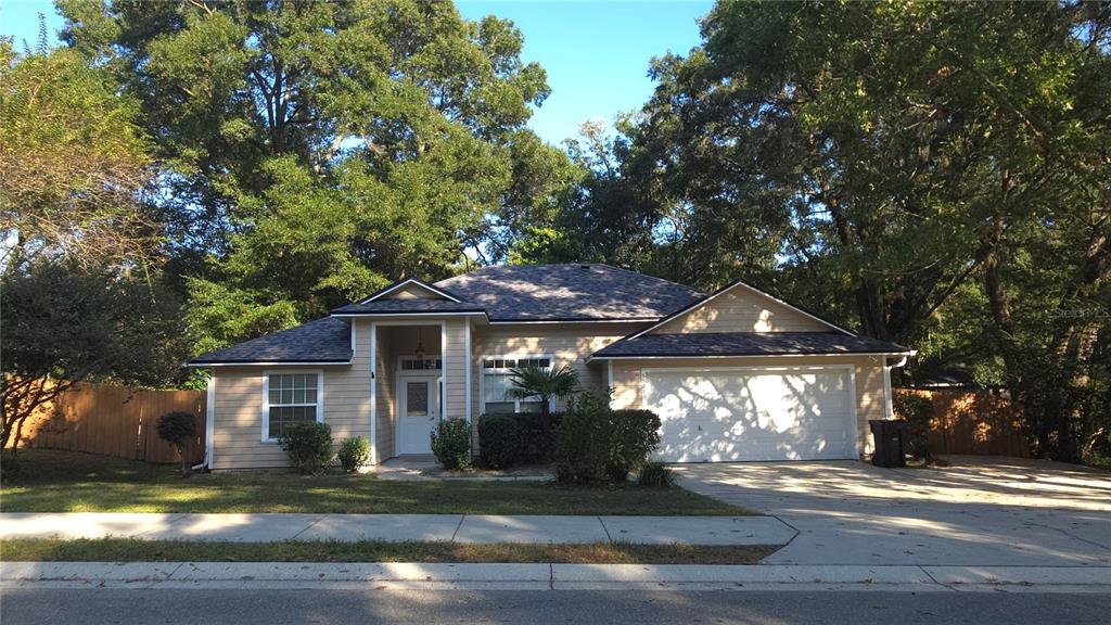 5909 Southwest 86th Drive Gainesville, FL 32608 - Photo 1 of 22 a front view of a house with garden