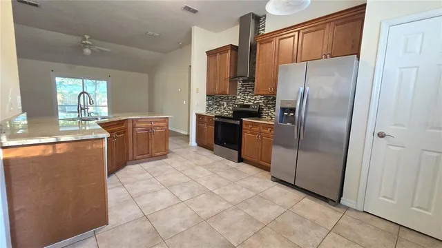 a kitchen with stainless steel appliances granite countertop a refrigerator a sink a stove and island