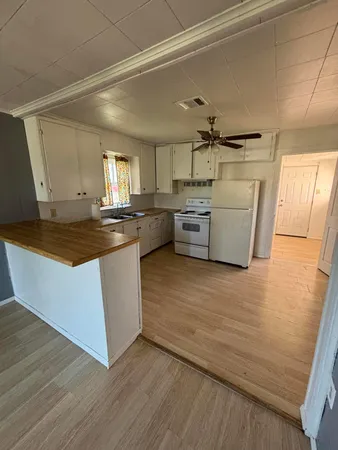 a kitchen with granite countertop a stove and wooden floor