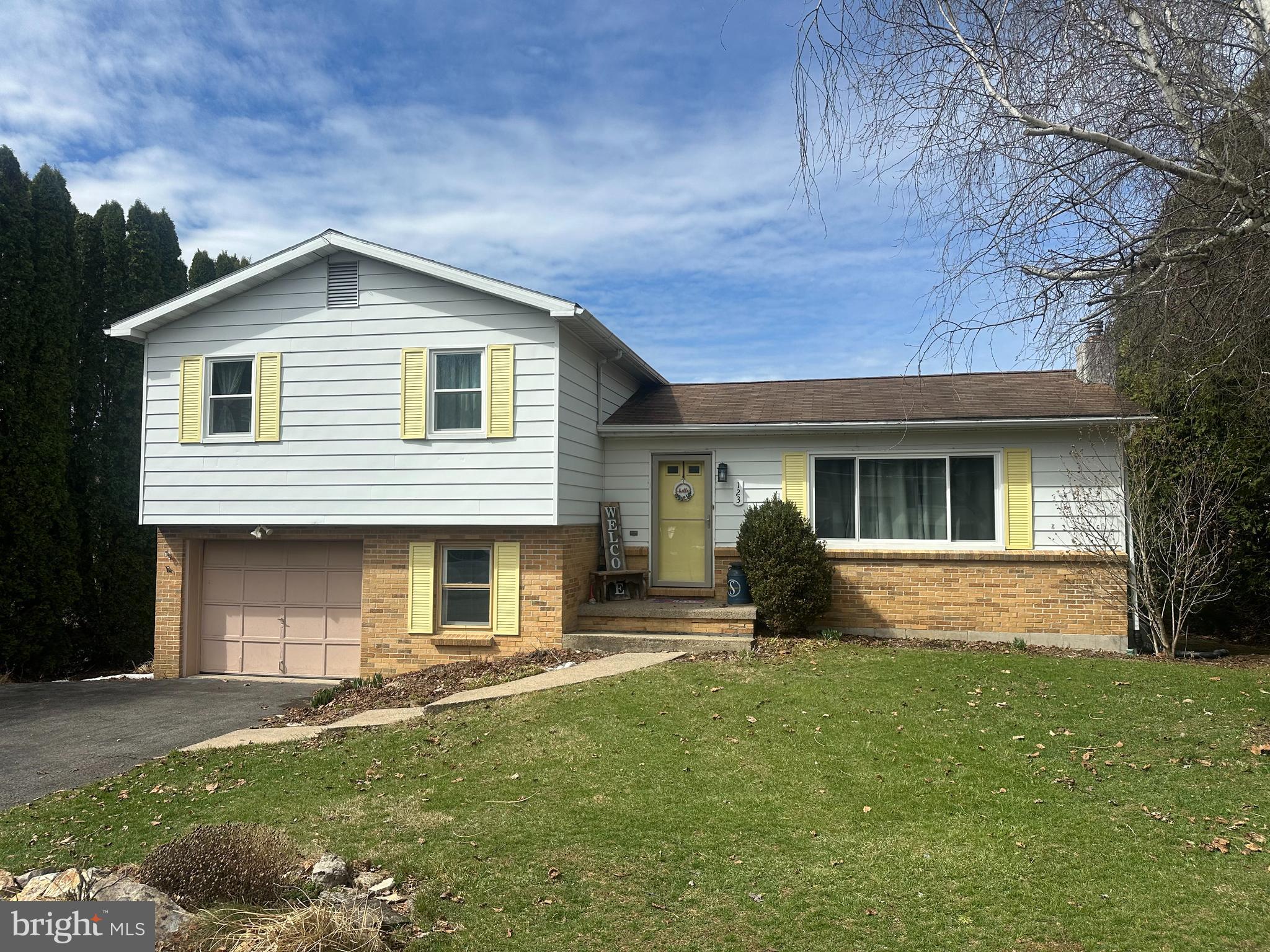 a front view of a house with a garden and yard