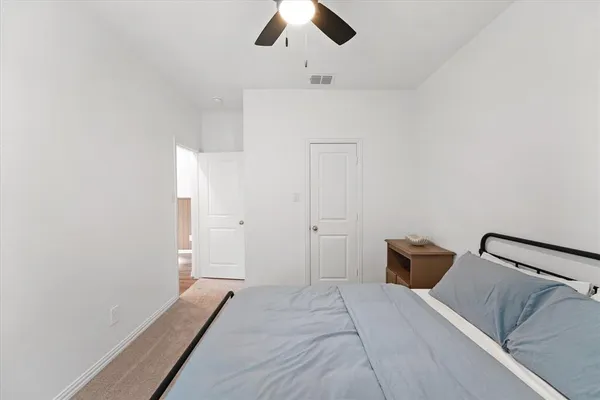 a bedroom with a bed and a ceiling fan
