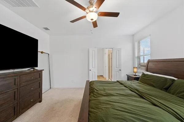 a bedroom with a large bed and a flat screen tv