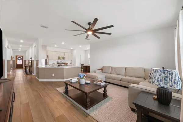 a living room with furniture and a view of kitchen