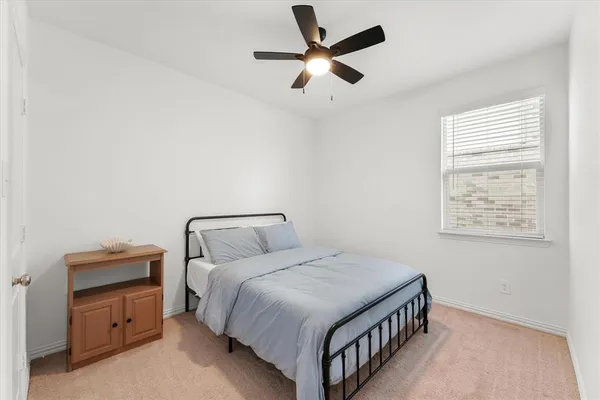 a bedroom with a bed and a ceiling fan