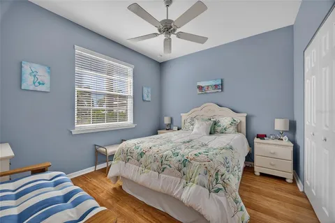 a bedroom with a bed and a chandelier fan