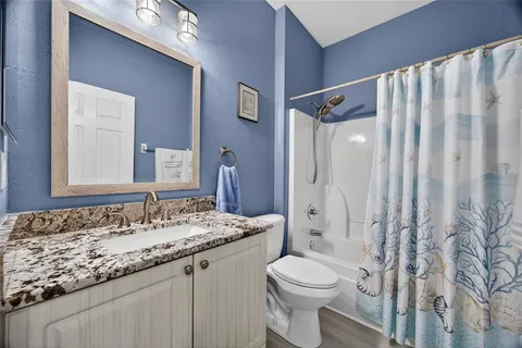 a bathroom with a granite countertop sink toilet and shower