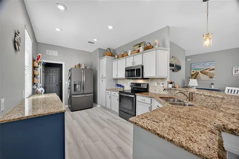 a large kitchen with kitchen island granite countertop a sink counter space and stainless steel appliances