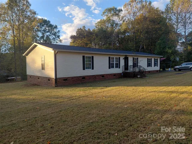 a view of a house with backyard and trees