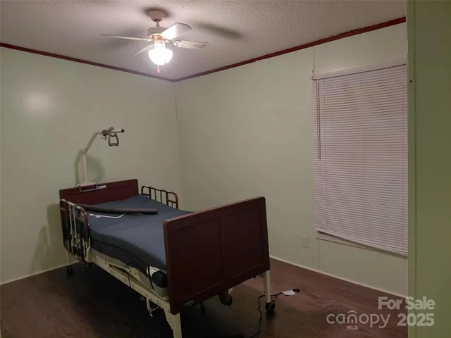 a bedroom with a bed and a chandelier fan