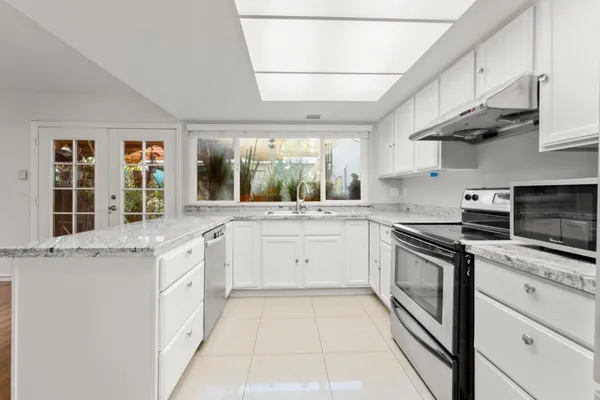 a kitchen with stainless steel appliances granite countertop a stove sink and cabinets