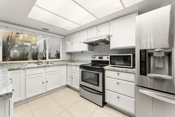 a kitchen with stainless steel appliances white cabinets and a sink