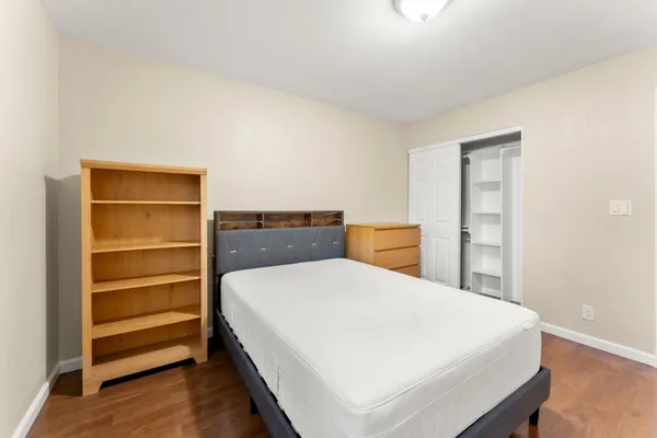 a bedroom with a bed and a painting on the wall