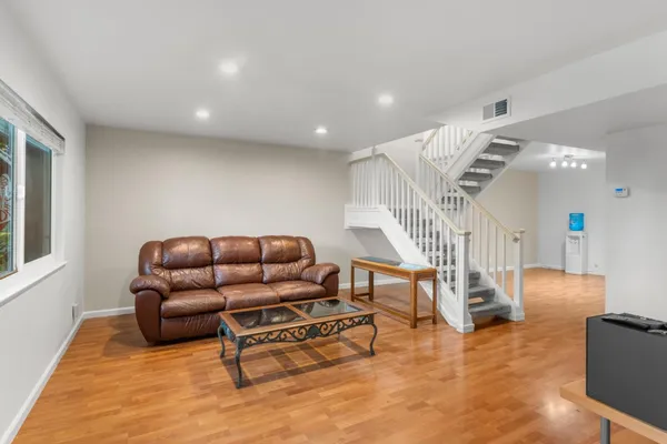 a living room with furniture and a wooden floor