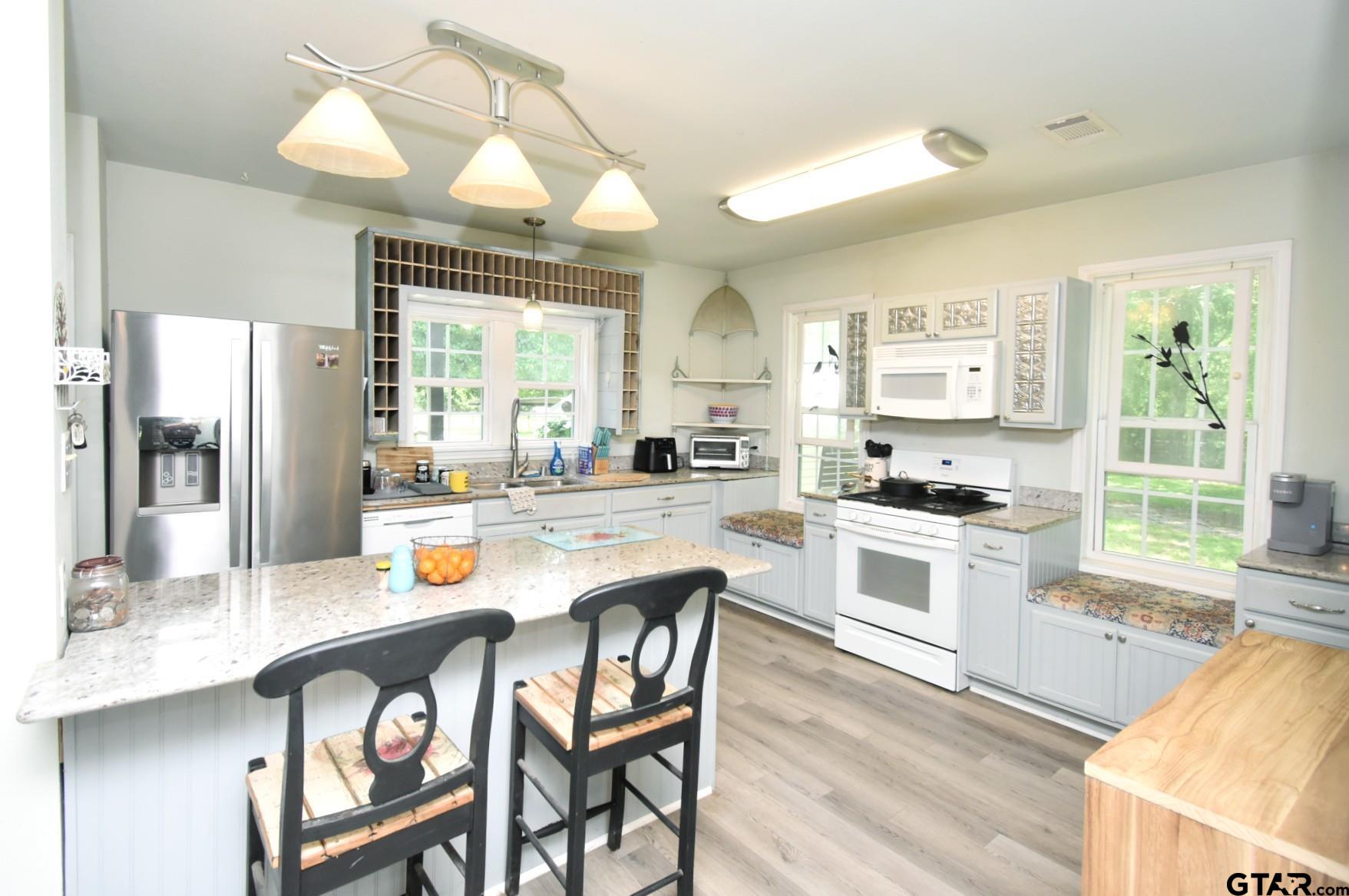 370 Spur 514 Yantis, TX 75497 - Photo 21 of 38 a kitchen with stainless steel appliances granite countertop a stove a sink dishwasher a refrigerator with a dining table and chairs