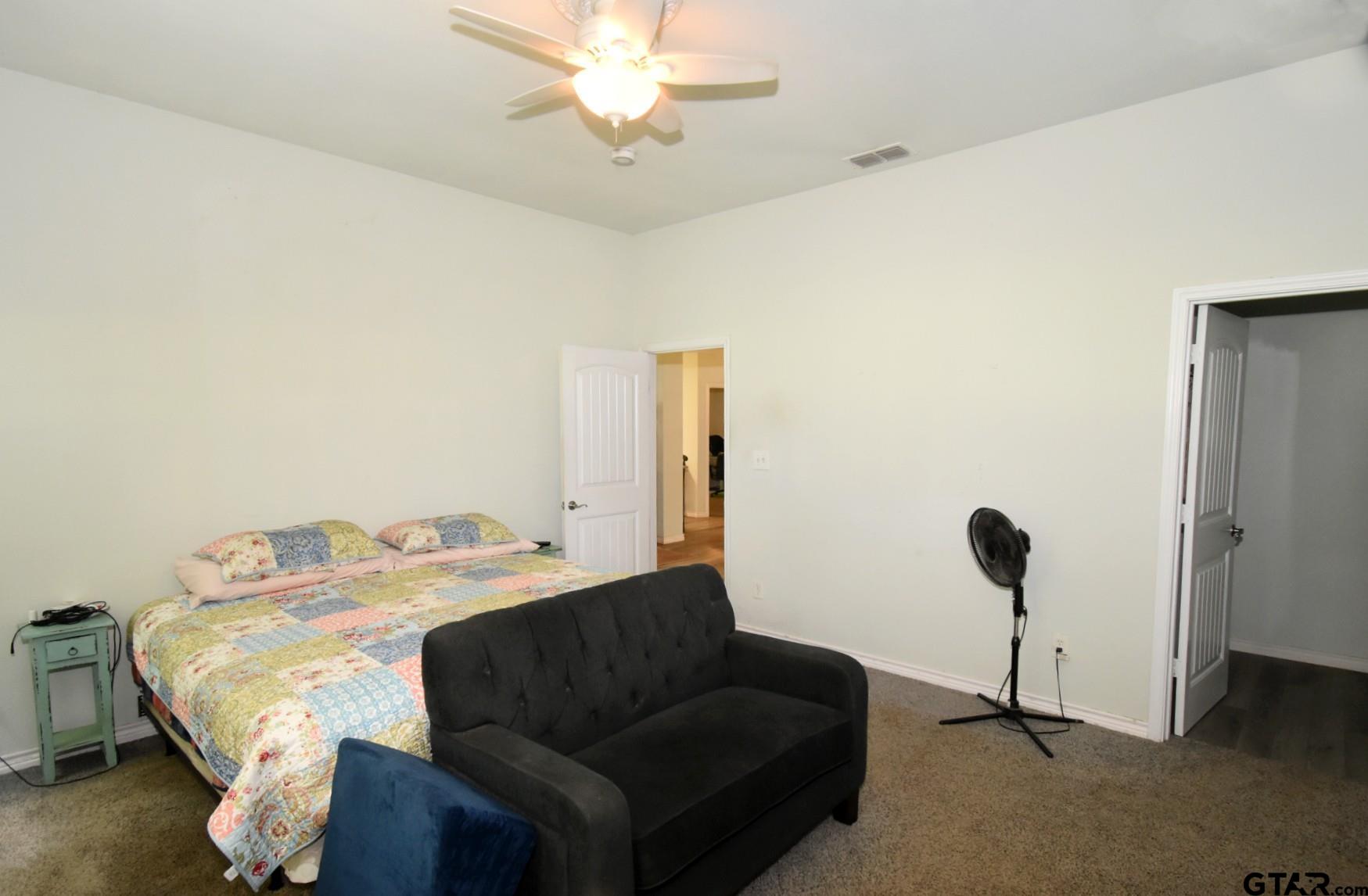 370 Spur 514 Yantis, TX 75497 - Photo 26 of 38 a bedroom with a bed and a chandelier