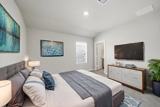 a bedroom with a bed and a flat screen tv