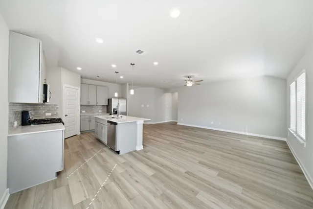 a kitchen with a sink cabinets and wooden floor