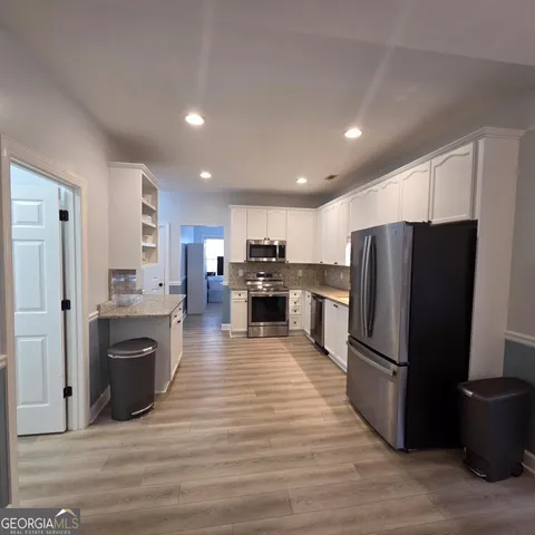 a kitchen with stainless steel appliances granite countertop a refrigerator stove and oven