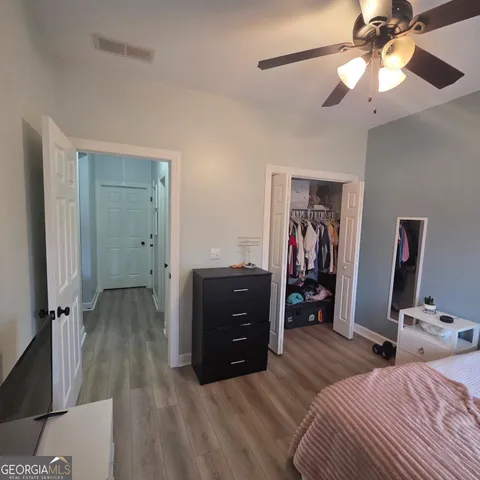 a bedroom with a bed and a mirror on the dresser